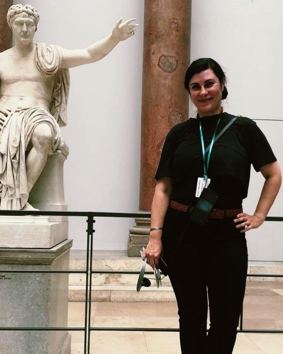 Eleonora, art educator and founder of Gallery & Graphite, beside a classical Roman statue